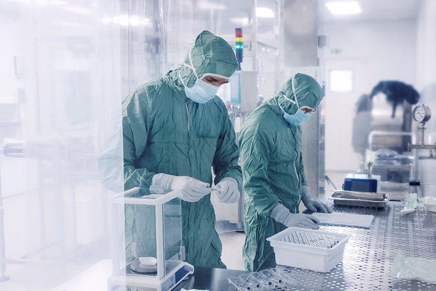 Two persons working in a clean-room for medicinal production