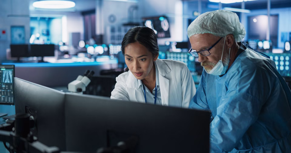Two persons in a research laboratory, viewing a computer screen