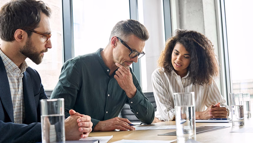 A Quality management team reviewing documents in a conference room